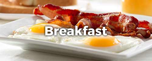 Eggs and bacon on a plate with the word Breakfast written on top